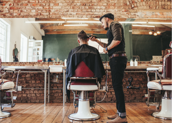 Barber cuts the hair of their client at a barbershop